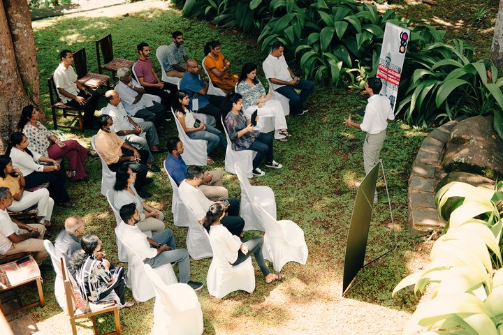 Sukhith speaking to a group in a garden